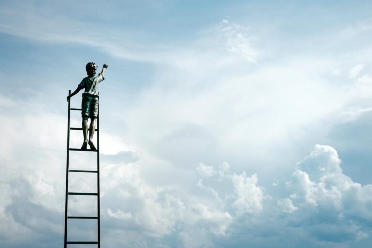 Boy dreamer on top of ladder as symbol of individual sucess