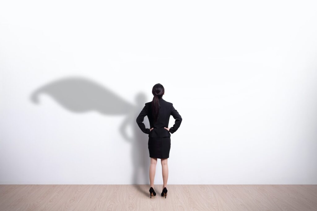 Woman looking at her shadow with a cape