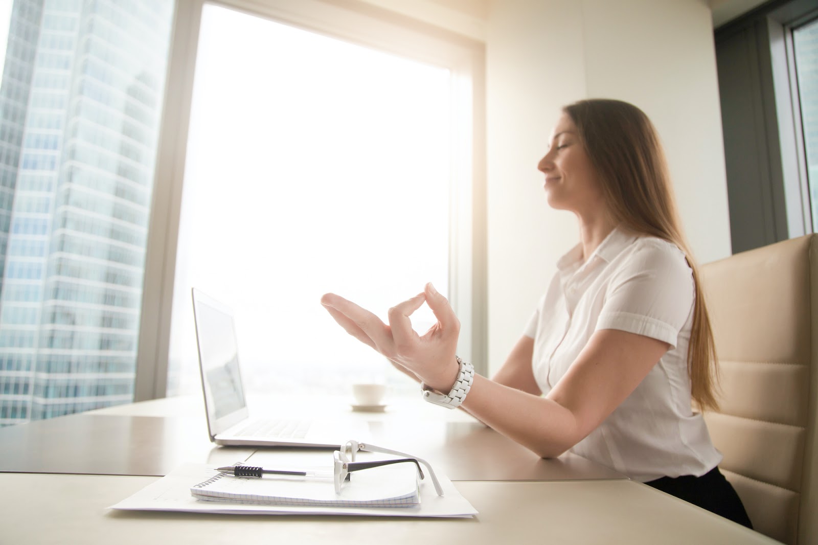 Woman doing breathing exercise at laptop