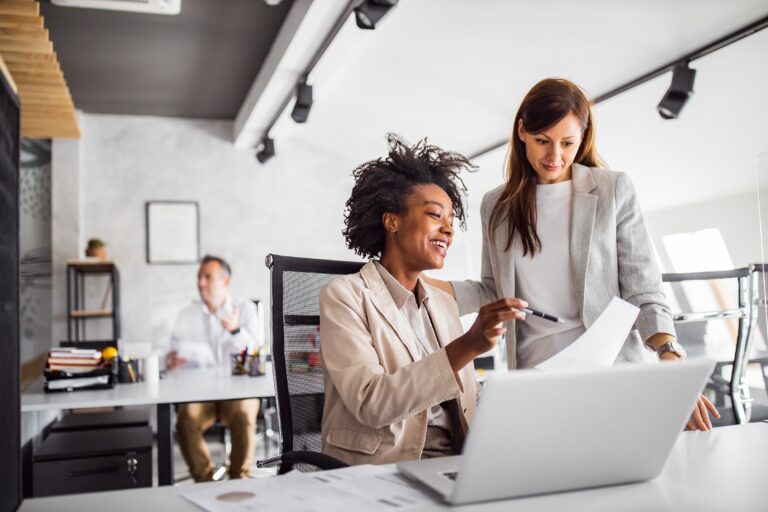 Two women having discussion in front of computer