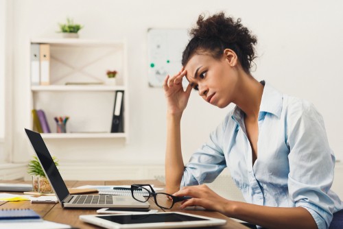 Woman at computer appearing stressed