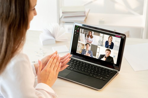 Woman clapping her hands while having a virtual meeting on her computer