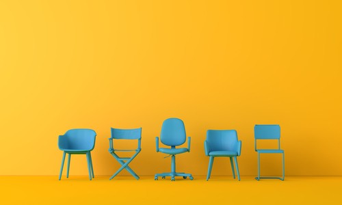 Orange background with 5 empty blue chairs awaiting employees