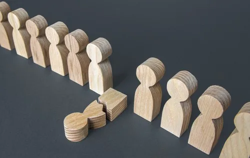 Wooden people characters in which one has fallen down and broken