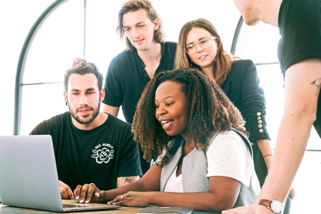 a group of people around a laptop