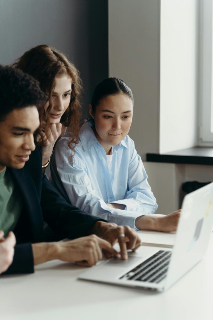 a group of people looking at a laptop